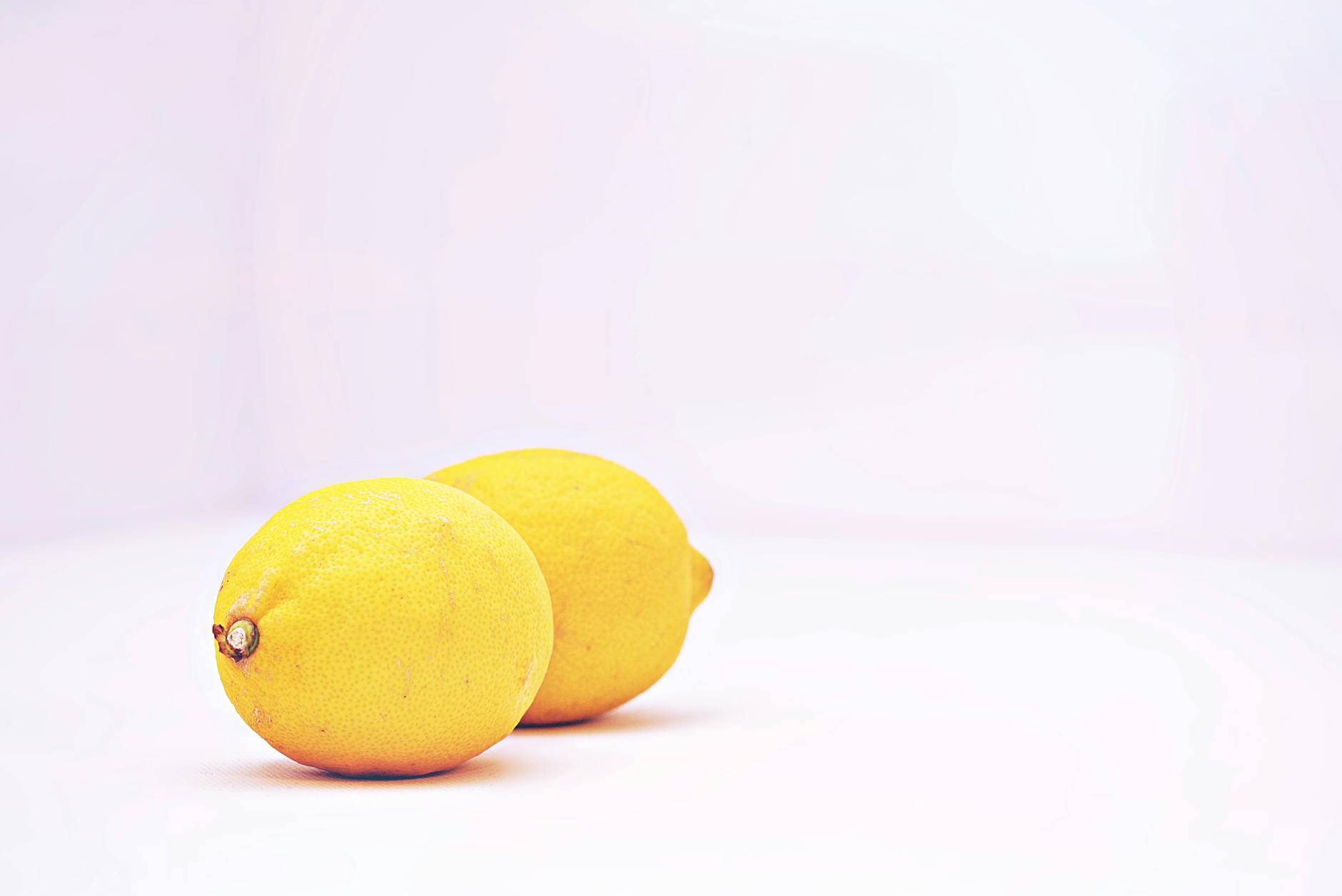 Hand holding an orange vibrator against a minimalistic purple backdrop, showcasing modern sensuality