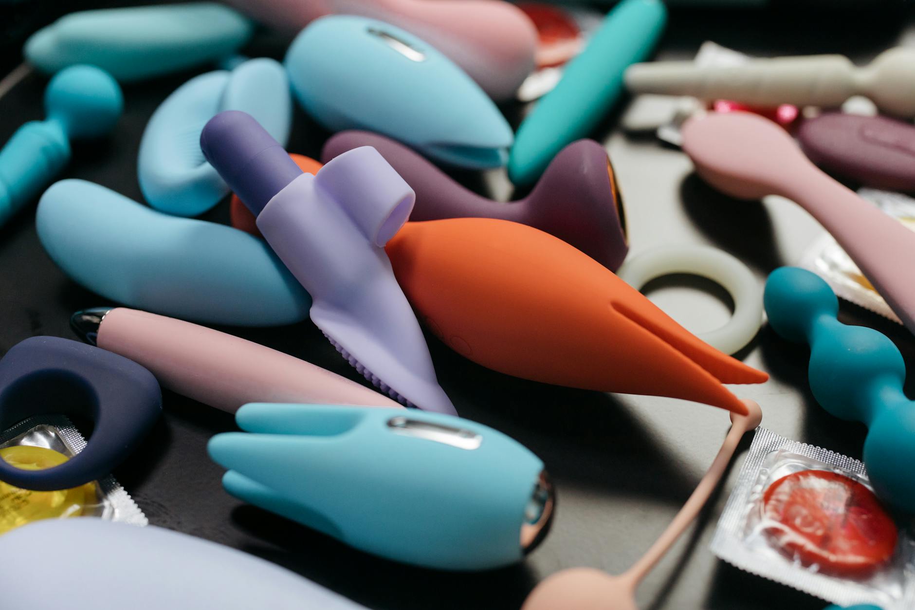 Array of vibrant adult toys including air-pulse vibrators and silicone toys in close-up view