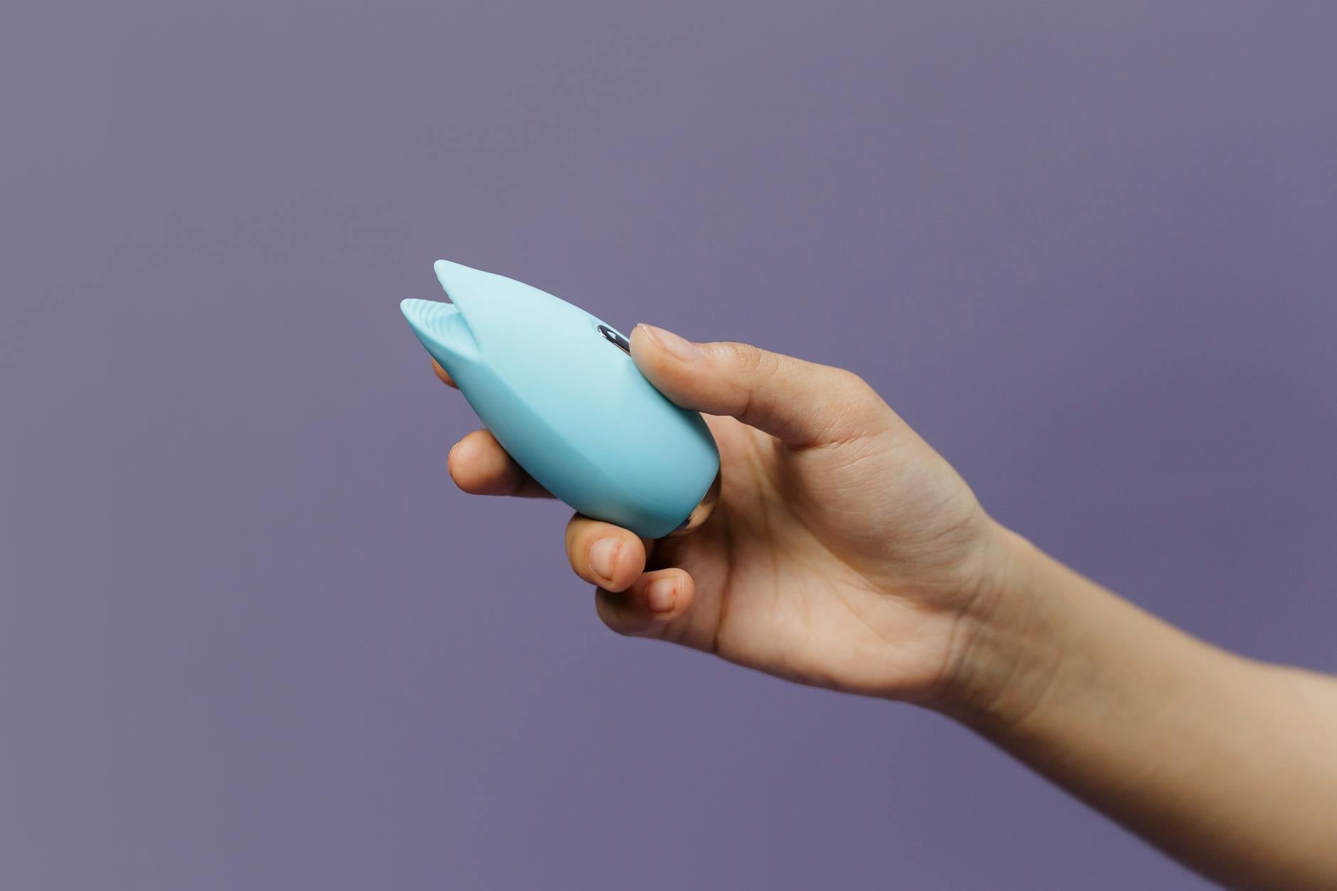Yellow silicone lemon vibrator surrounded by peeled bananas on bright yellow background