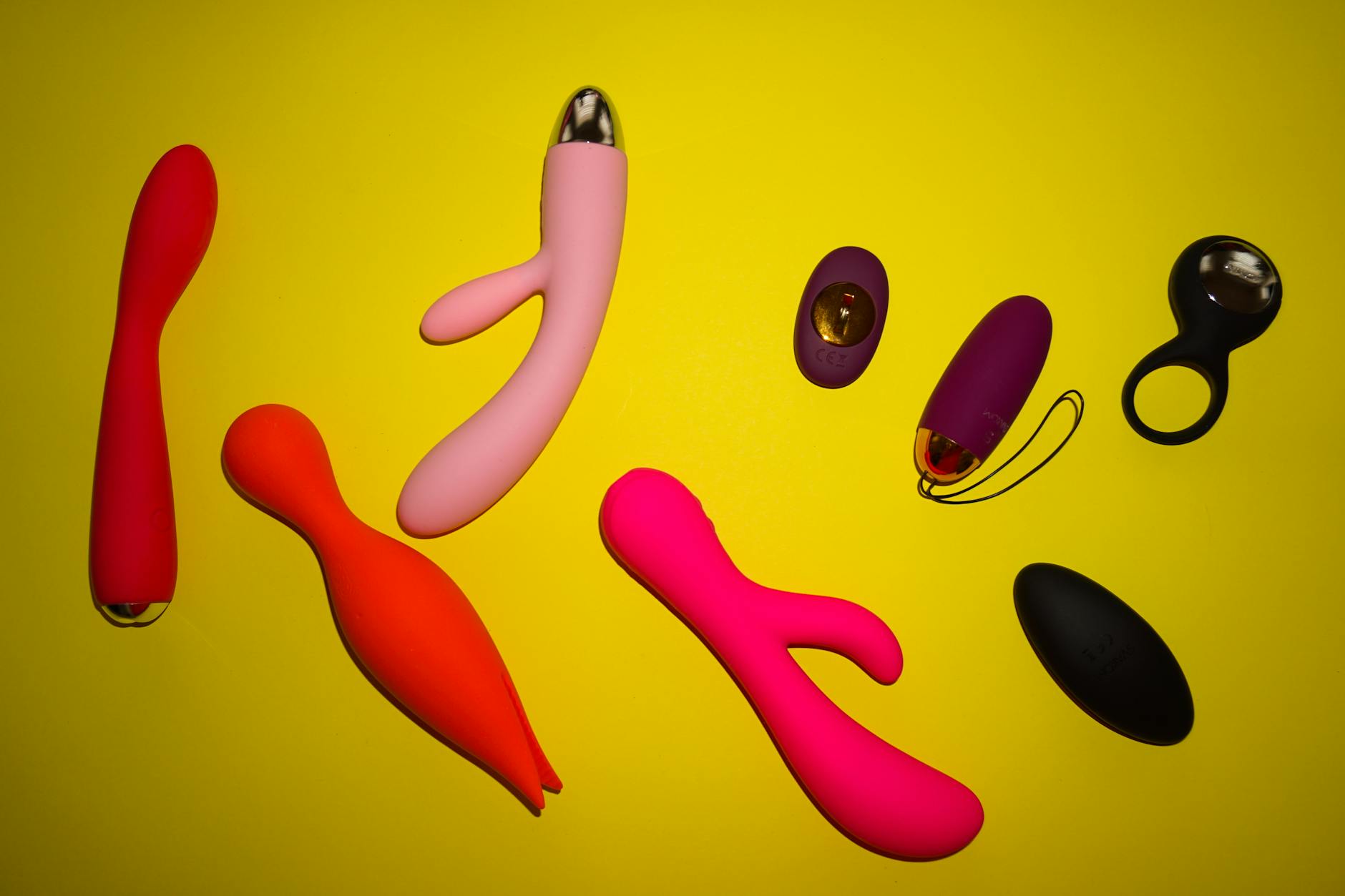 Hand holding a blue clitoral vibrator against a solid background, representing intentional self-pleasure and relaxation